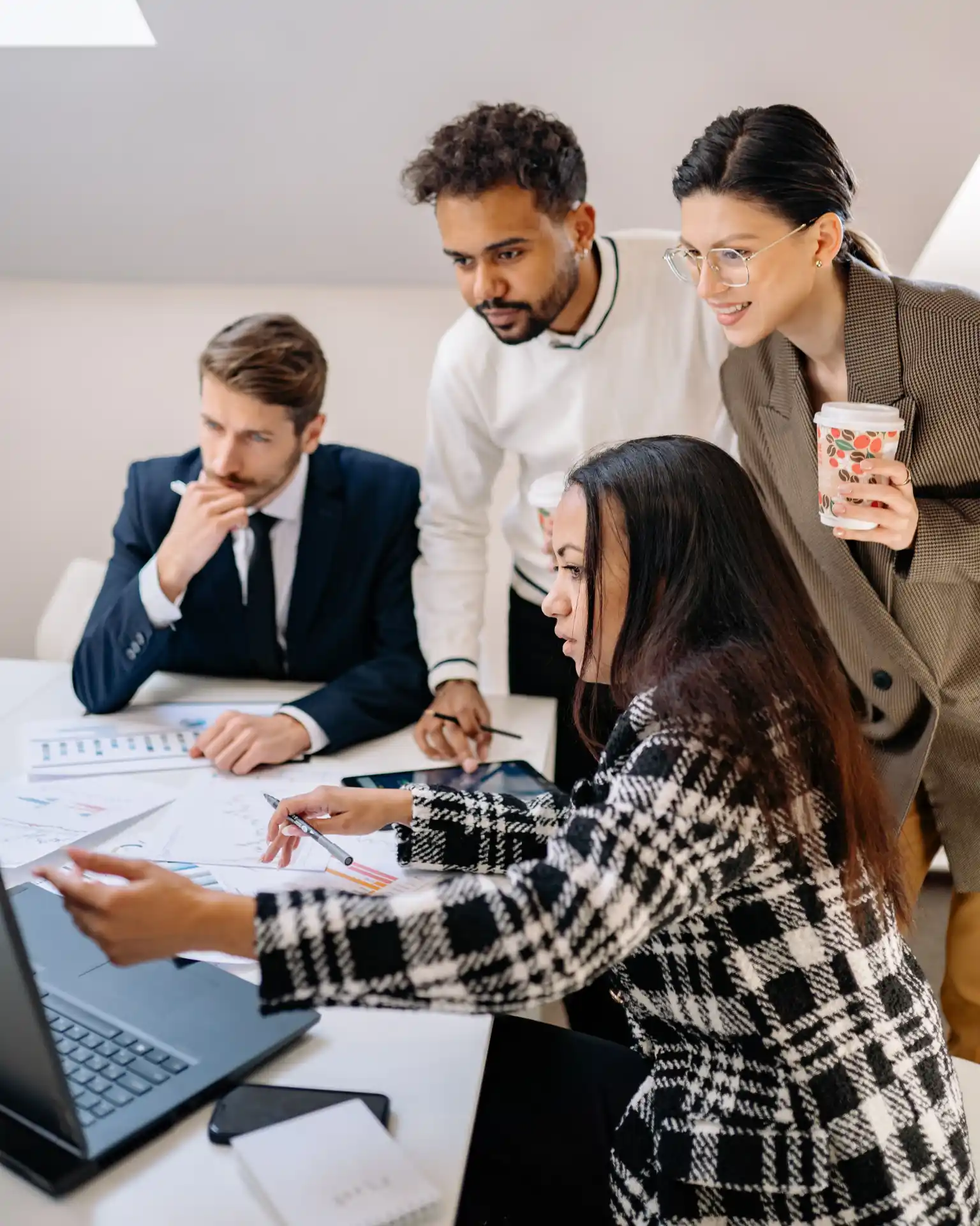 Fotografie von glücklicher Gruppe im Businesskontext, die gemeinsam auf einen Laptop sich die Ergebnisse nach erfolgreicher Zusammenarbeit mit DigiMatch Tech Gründer Carlos Derksen anschaut